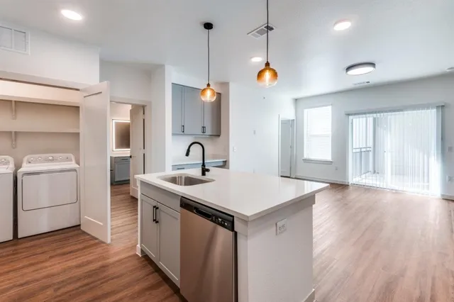 a kitchen with a sink stove and wooden floor