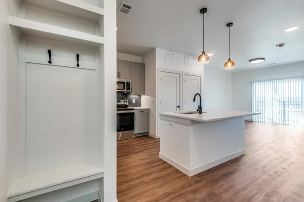 a view of a kitchen counter space a sink and wooden floor