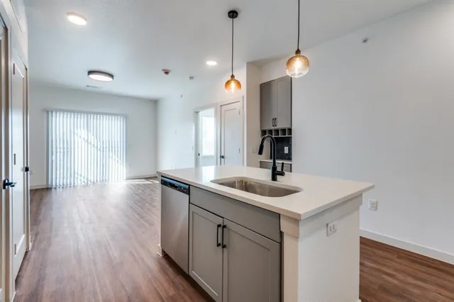 a view of a kitchen counter space a sink and wooden floor