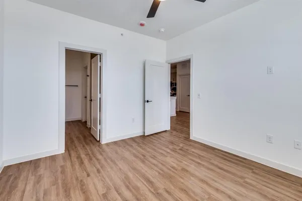 a living room with stainless steel appliances kitchen island granite countertop a refrigerator a sink a stove and a wooden floors