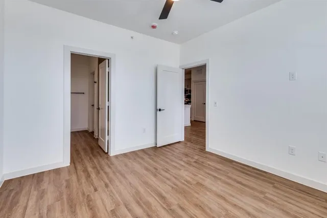 a living room with stainless steel appliances kitchen island granite countertop a refrigerator a sink a stove and a wooden floors