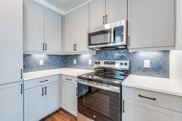 a kitchen with white cabinets and appliances