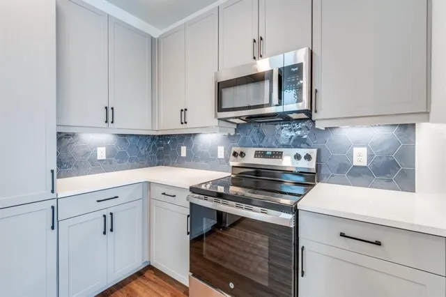 a kitchen with white cabinets and appliances