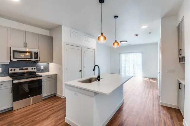 a view of a kitchen with wooden floor and a sink