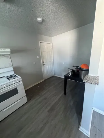 a kitchen with stainless steel appliances granite countertop a stove a sink and white cabinets