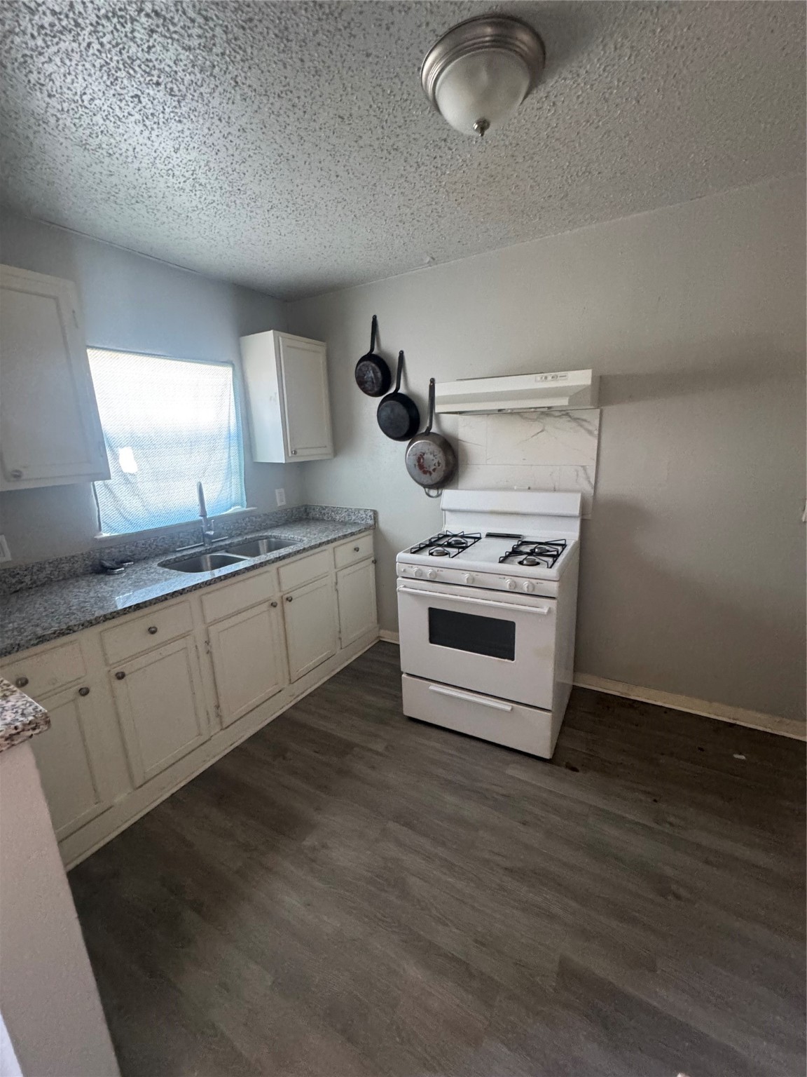 7018 Avenue F, Unit 1 Houston, TX 77011 - Photo 4 of 7 a kitchen with stainless steel appliances granite countertop a stove a sink and white cabinets