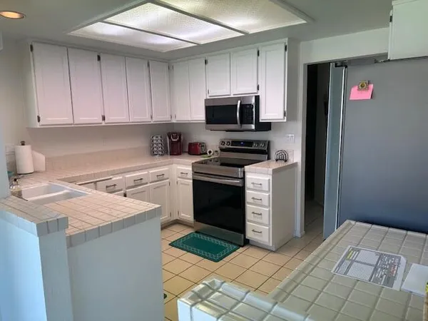 a kitchen with a stove sink and cabinets
