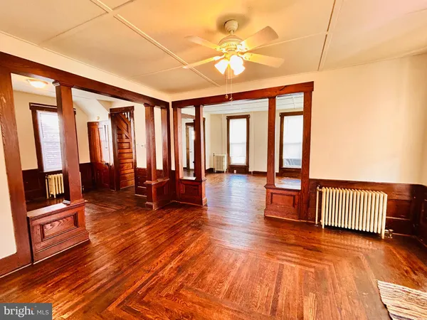 a living room with furniture a wooden floor and floor to ceiling windows