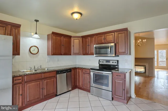a kitchen with stainless steel appliances granite countertop a stove microwave and sink