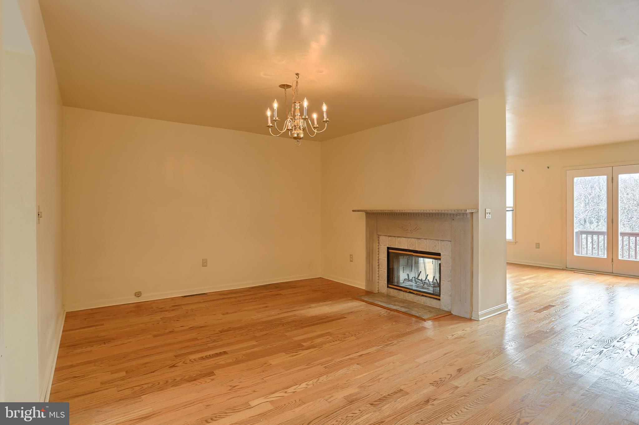 2051 B Raleigh Road, Unit B Hummelstown, PA 17036 - Photo 8 of 27 an empty room with a fireplace and chandelier