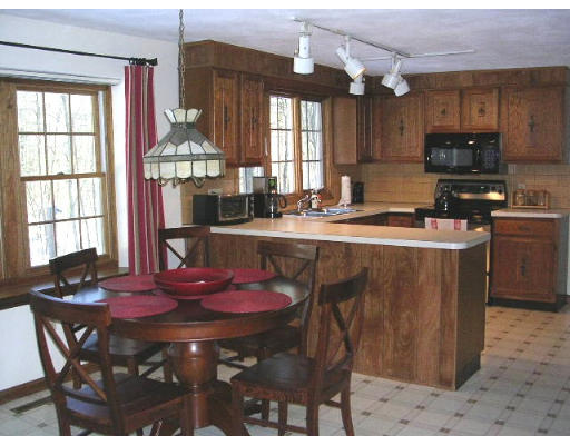 135 Taylor Road Stow, MA 01775 - Photo 3 of 14 a kitchen with stainless steel appliances granite countertop a sink a stove a table and chairs
