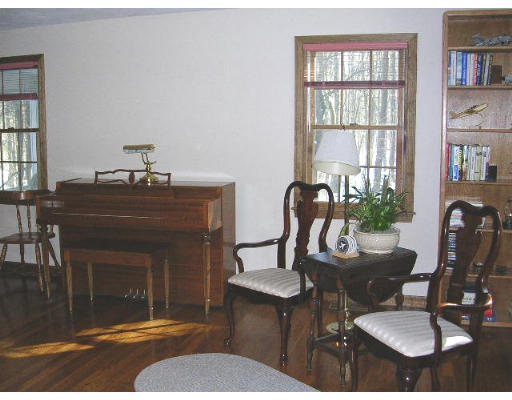 135 Taylor Road Stow, MA 01775 - Photo 7 of 14 a living room with furniture a bookshelf and a fireplace