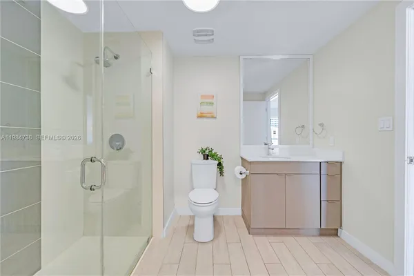 a bathroom with a sink a toilet and shower
