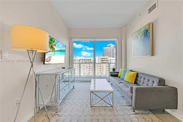 a living room with furniture and a floor to ceiling window