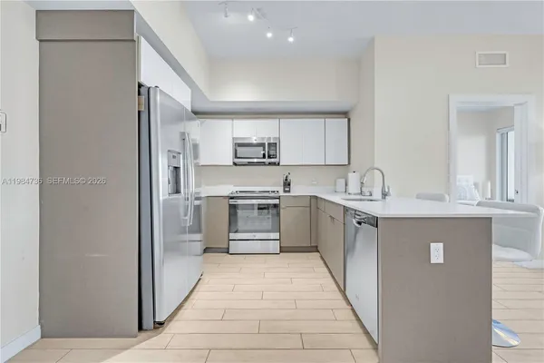 a kitchen with stainless steel appliances a refrigerator sink and microwave