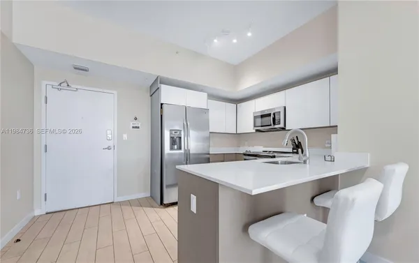 a kitchen with a sink cabinets and wooden floor