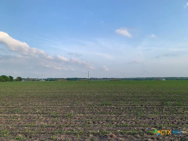 a view of a field and an ocean in back