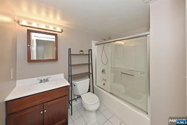 a bathroom with a toilet a sink a mirror and shower