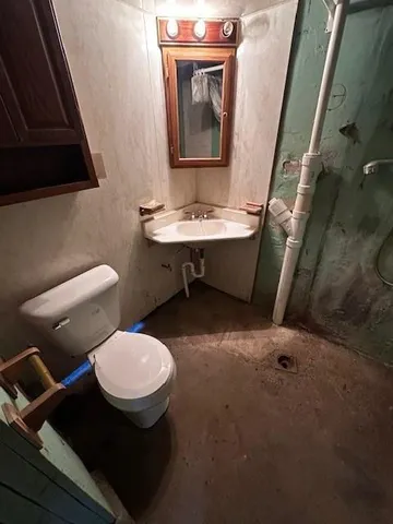 a bathroom with a toilet sink and mirror