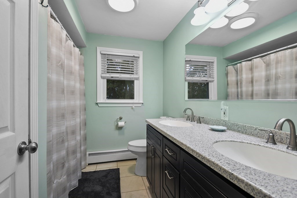 26 Westwood Road Webster, MA 01570 - Photo 18 of 30 a bathroom with a granite countertop sink a large mirror and a shower