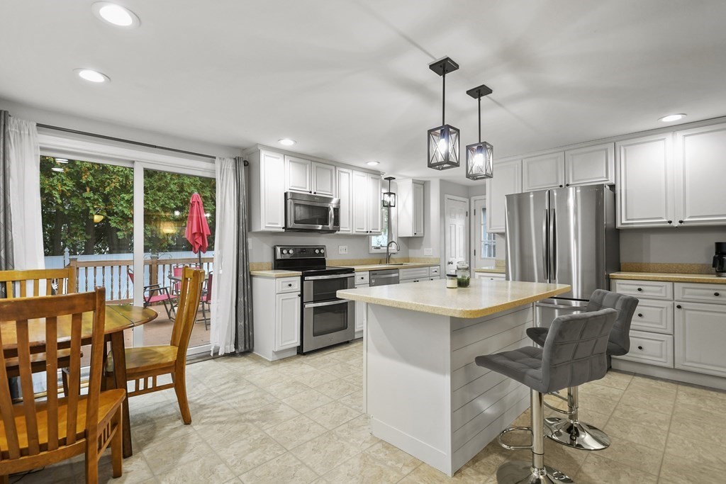 26 Westwood Road Webster, MA 01570 - Photo 9 of 30 a kitchen with stainless steel appliances a dining table chairs stove refrigerator and cabinets