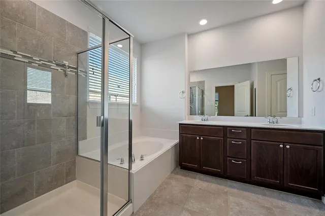 a spacious bathroom with a tub sink shower and mirror