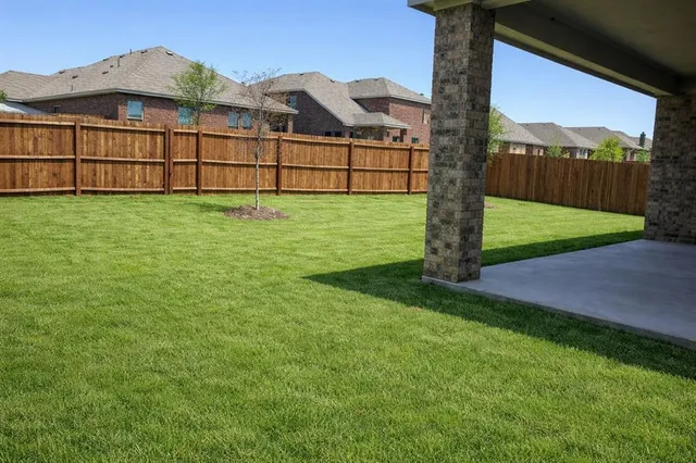 a view of a house with a big yard and large tree