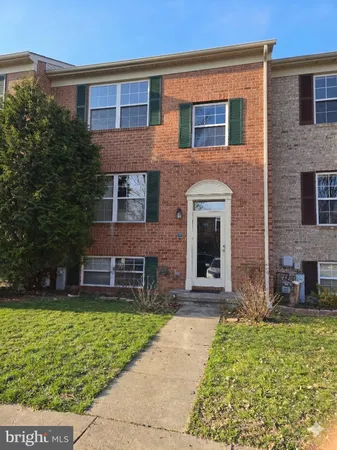 front view of a brick house with a yard