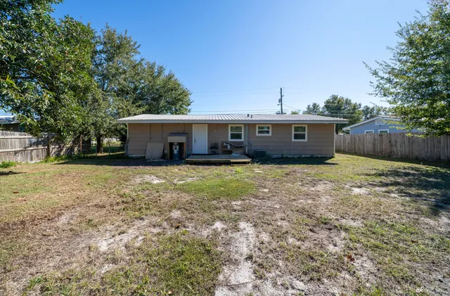 a view of house with backyard space and wooden fence