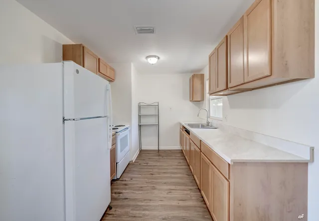a kitchen with granite countertop stainless steel appliances a refrigerator and a sink