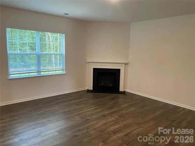 an empty room with wooden floor and a window