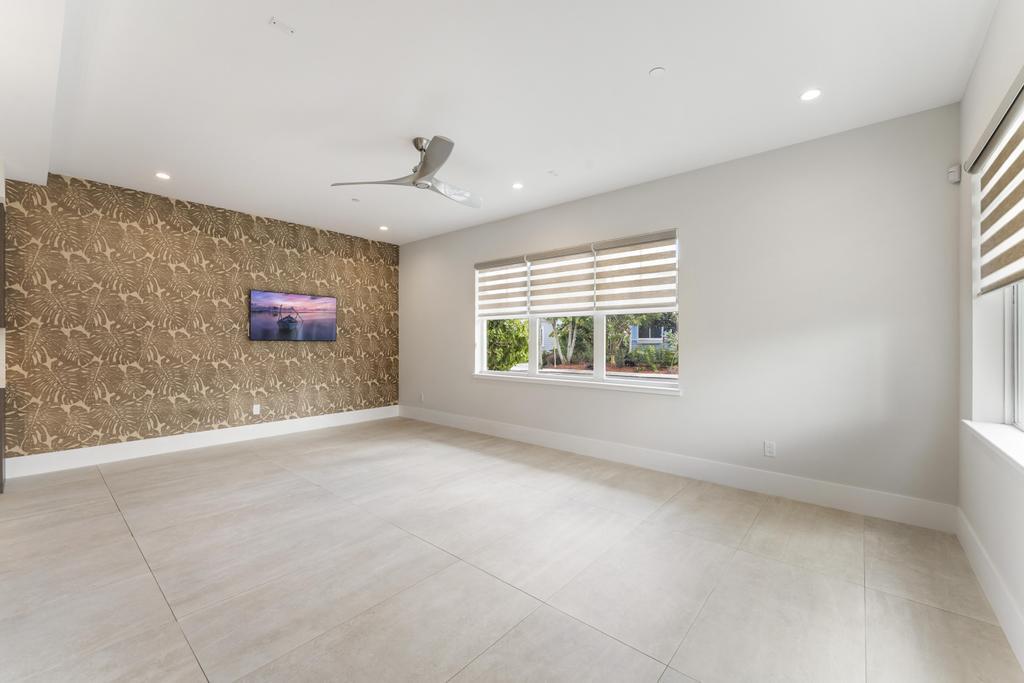 53 Southeast Seminole Street, Unit A Stuart, FL 34994 - Photo 12 of 75 an empty room with windows and ceiling fan