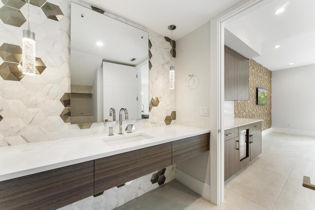 53 Southeast Seminole Street, Unit A Stuart, FL 34994 - Photo 26 of 75 a bathroom with a sink double vanity granite tub shower and a mirror