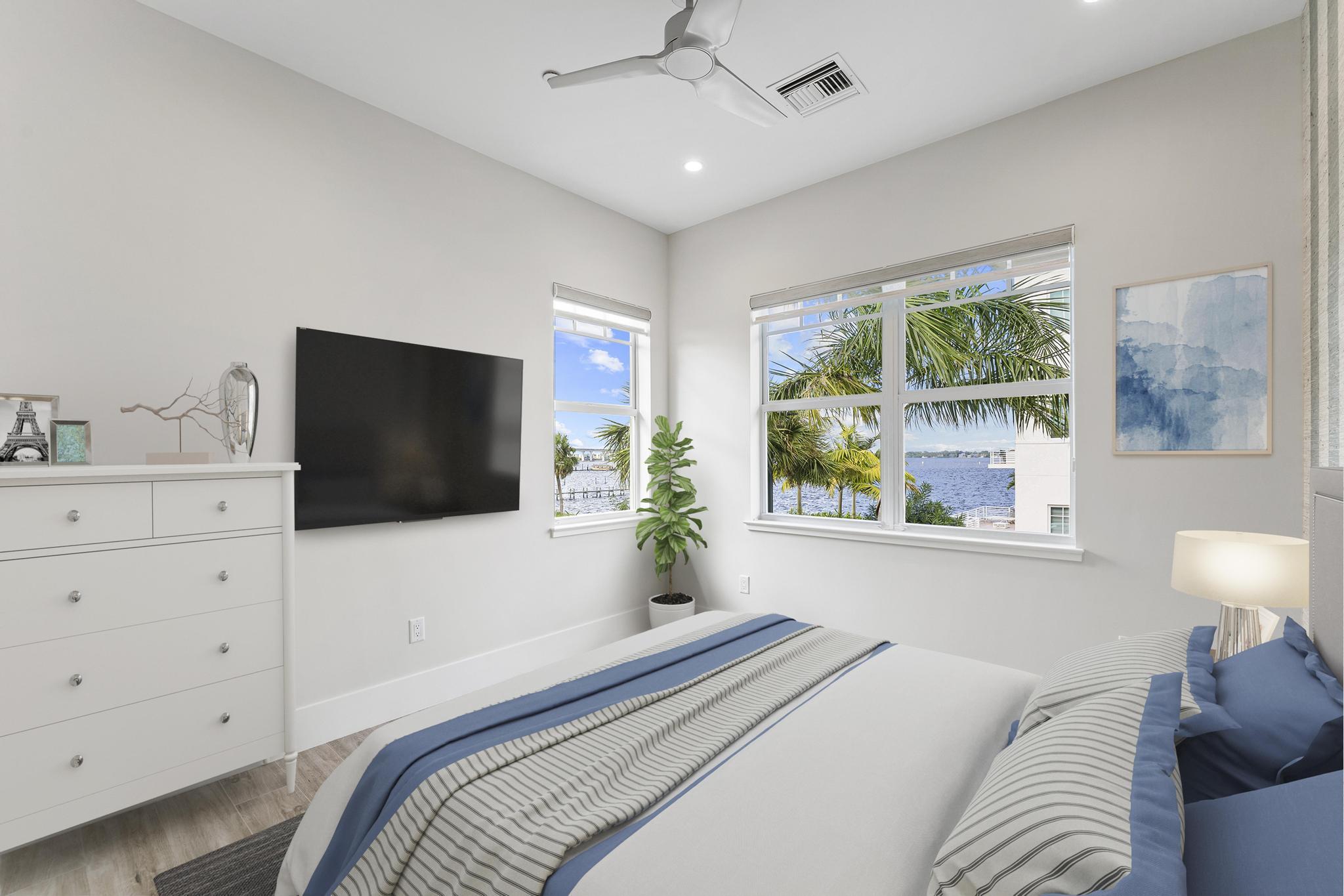 53 Southeast Seminole Street, Unit A Stuart, FL 34994 - Photo 44 of 75 a bedroom with a large bed and a flat screen tv