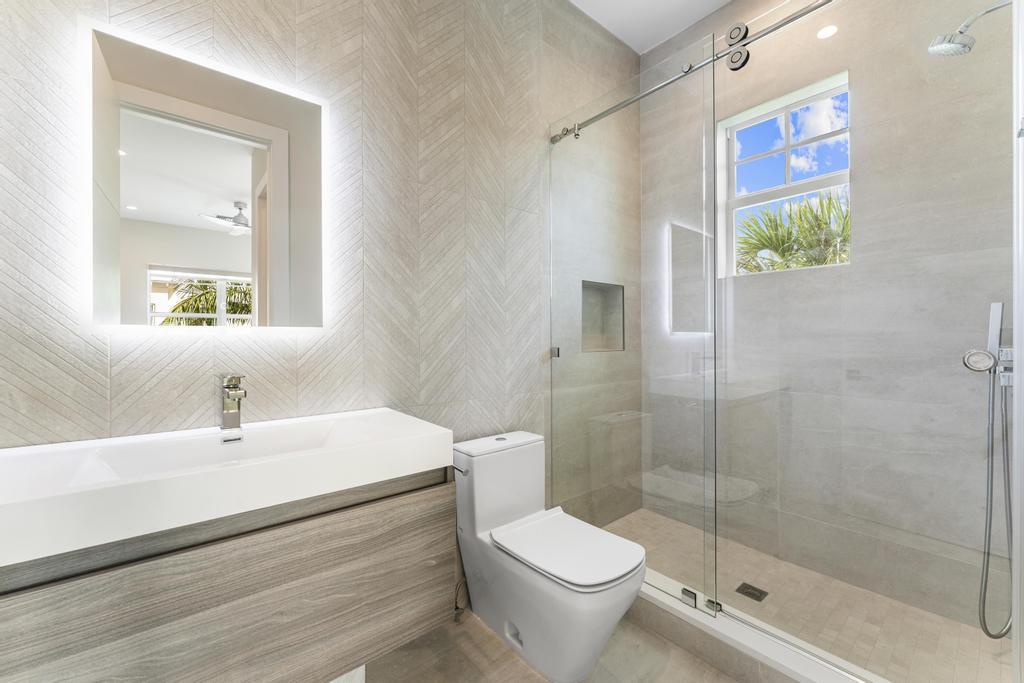 53 Southeast Seminole Street, Unit A Stuart, FL 34994 - Photo 50 of 75 a bathroom with a sink a toilet and shower