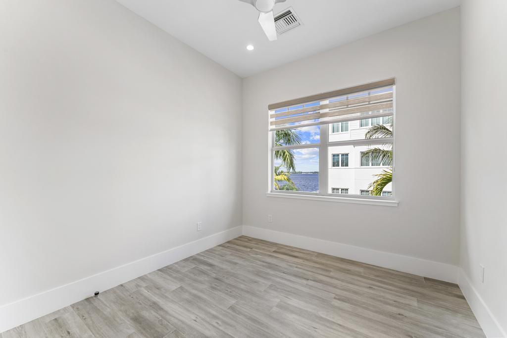 53 Southeast Seminole Street, Unit A Stuart, FL 34994 - Photo 52 of 75 an empty room with window & wooden door