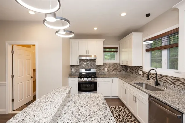 a kitchen with stainless steel appliances granite countertop a sink stove and refrigerator