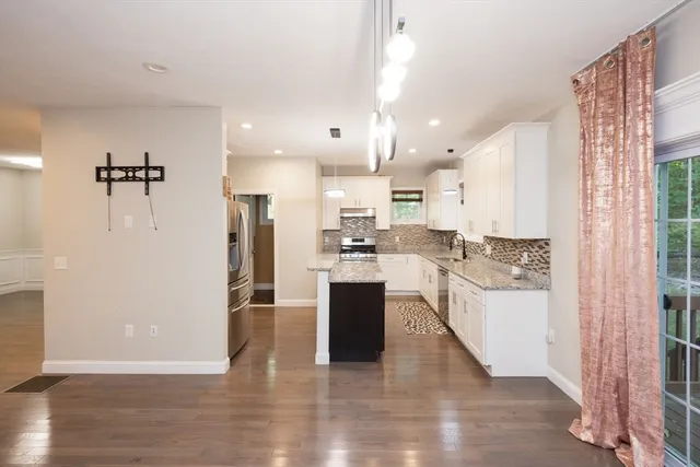 a large kitchen with a lot of counter space and wooden floor