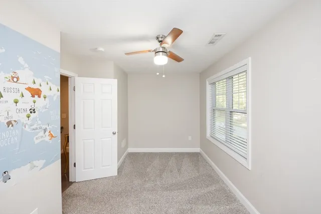 a view of empty room with window and ceiling fan
