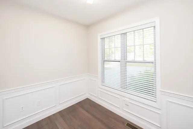a view of a small space with wooden floor and a window
