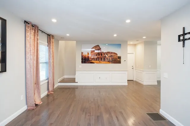 a view of a big room with wooden floor and windows