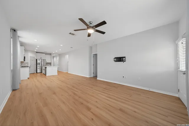 a view of empty room with wooden floor and windows