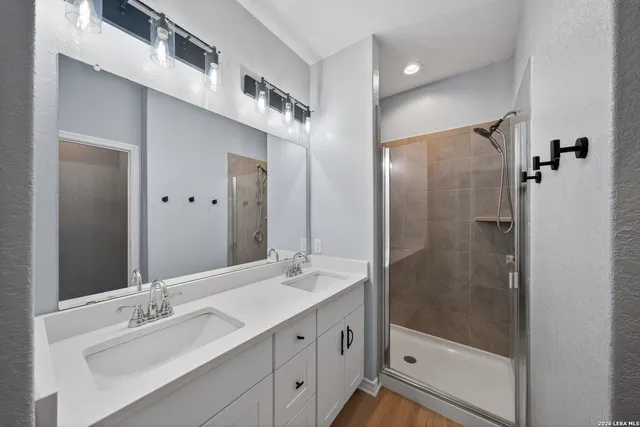 a bathroom with a shower sink and mirror