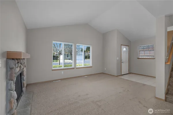 a view of empty room with windows and fireplace