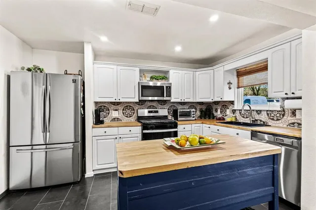 a kitchen with a refrigerator a stove a microwave a sink and cabinets