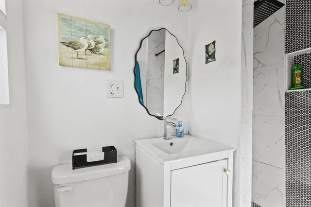 a bathroom with a toilet sink and mirror