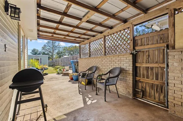a backyard of a house with barbeque oven table and chairs