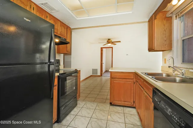 a kitchen with stainless steel appliances granite countertop a sink and a refrigerator