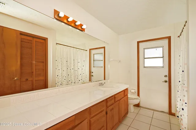 a spacious bathroom with a granite countertop sink a toilet and shower