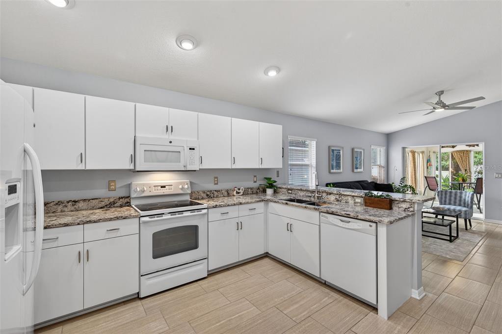 12629 White Bluff Road Hudson, FL 34669 - Photo 6 of 38 a kitchen with stainless steel appliances granite countertop a stove and white cabinets